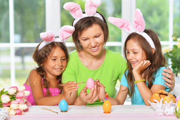 Mother and daughters coloring  Easter eggs   - Foto, afbeelding