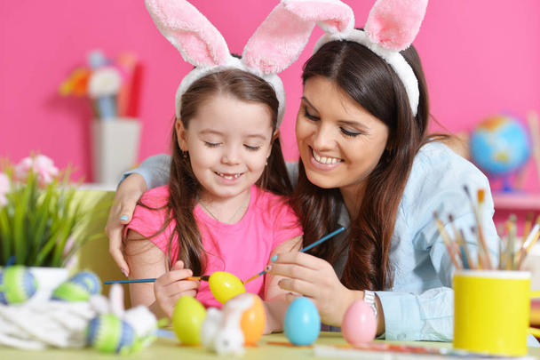 Mother and daughter decorating  Easter eggs   - Foto, afbeelding