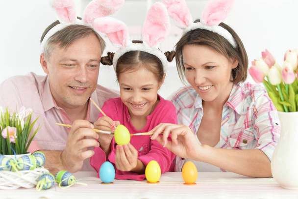 Parents with cute little daughter coloring eggs to Easter holiday - Foto, Imagem