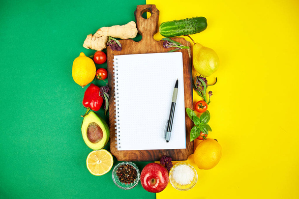 Shopping list, recipe book, diet plan. Fresh raw vegetables, fruit and ingredients for healthy cooking. top view, place for text. Diet or vegan food, healthily cooking concept. Flat lay. Notepad for your recipe concept. - Photo, Image