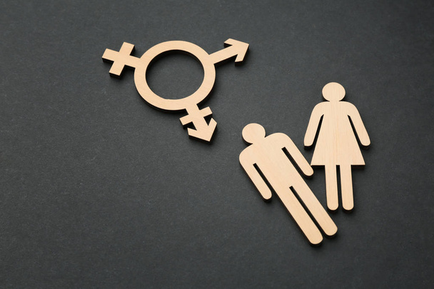Female and male figures with symbol of transgender on dark background - Photo, Image
