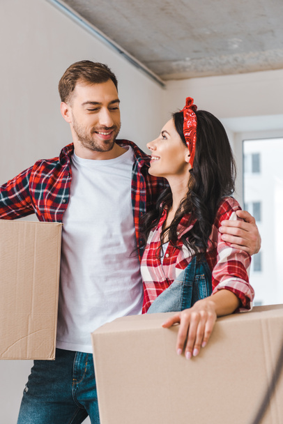 handsome boyfriend looking at girlfriend holding box at home - Photo, Image