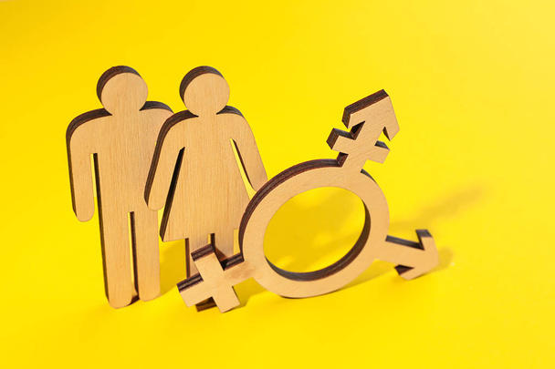 Female and male figures with symbol of transgender on color background - Photo, Image
