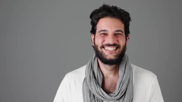 Opgewonden jonge man lachen tegen grijze achtergrond - Video