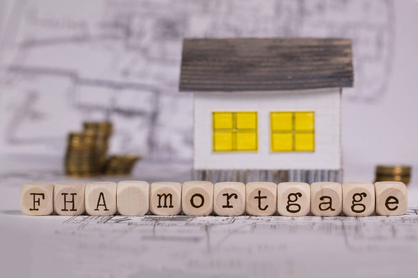 Abréviation Hypothèque FHA composée de lettres en bois. Petite maison en papier en arrière-plan. Gros plan
 - Photo, image