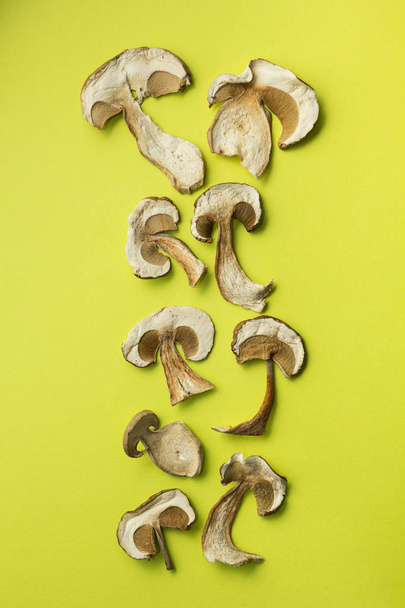 Dried mushrooms are isolated on a green background, vertically. - Foto, Bild
