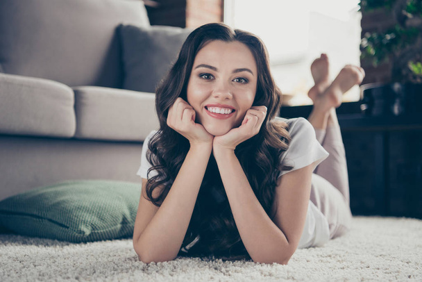 Close up photo sweet beautiful brunette she her lady housewife hands arms hold head affectionate best emotions wearing domestic light color t-shirt clothes outfit lying carpet floor divan - Fotoğraf, Görsel