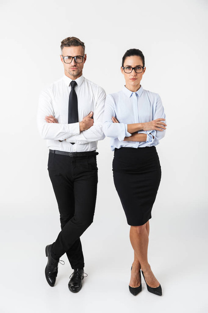 Full length of a confident colleagues couple wearing formal clothing standing isolated over white background, arms folded - Фото, зображення