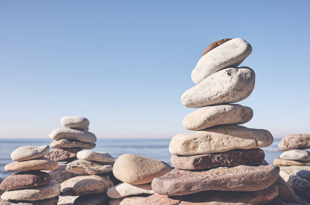 Pirâmides de pedra em uma praia, conceito de equilíbrio e harmonia, foco seletivo, tonificação de cor aplicada
. - Foto, Imagem