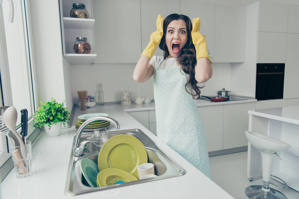 Portrait of her she nice lovely attractive beautiful mad scared frightened fury afraid wavy-haired house-wife screaming near dirty plates pile in modern light white interior indoors - 写真・画像