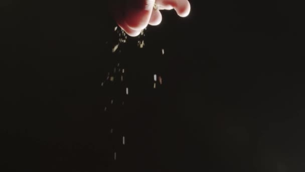 Pouring spice against dark background, slow motion shot - Filmati, video
