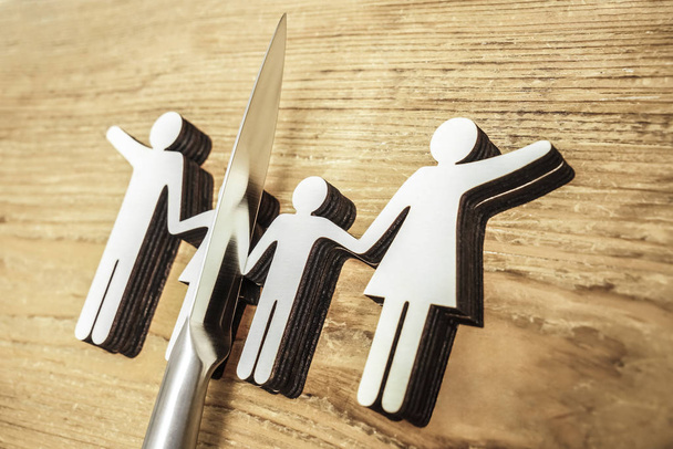 knife dividing  the whole family. divorce idea. wooden figures. wood background.  - Photo, Image