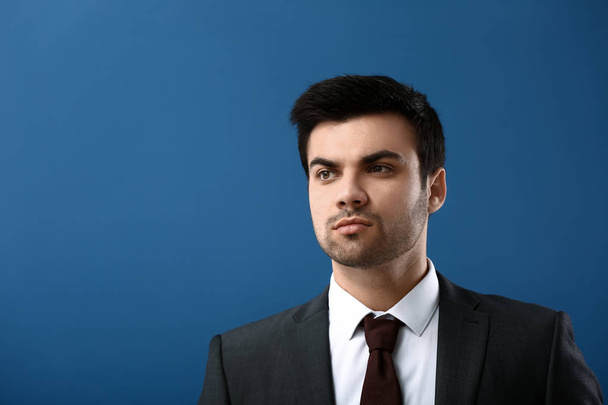 Portrait of handsome young businessman on color background - Photo, image