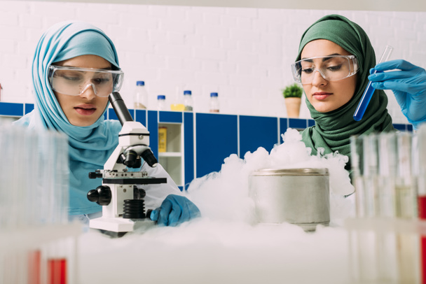científicas musulmanas que experimentan con microscopio, tubo de ensayo y hielo seco en laboratorio químico
 - Foto, Imagen