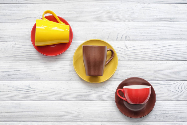 Diferentes tazas de té con platillos en mesa de madera blanca
 - Foto, Imagen