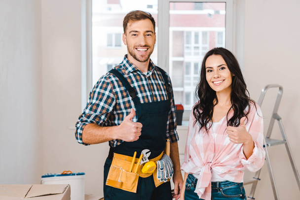 attractive woman and handsome handyman showing thumbs up - Photo, Image