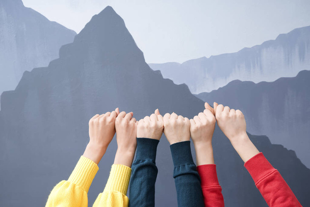 Руки молодих жінок зі згорнутими кулаками на сірому фоні. Концепція дружби
 - Фото, зображення