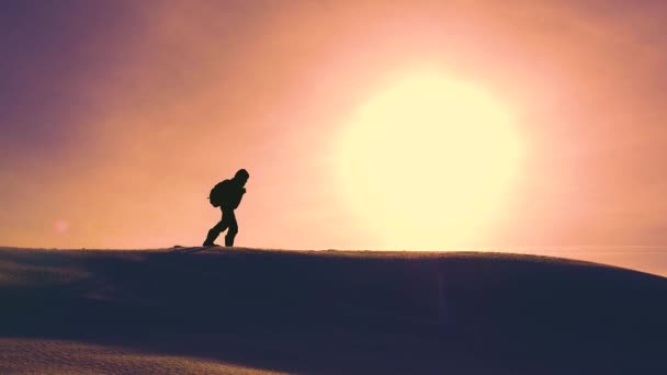 Travelers in winter go to snow ridge, overcoming difficulties in rays of a yellow sunset. well-coordinated teamwork in winter tourism. climbers go through snow at top of holom. - Footage, Video