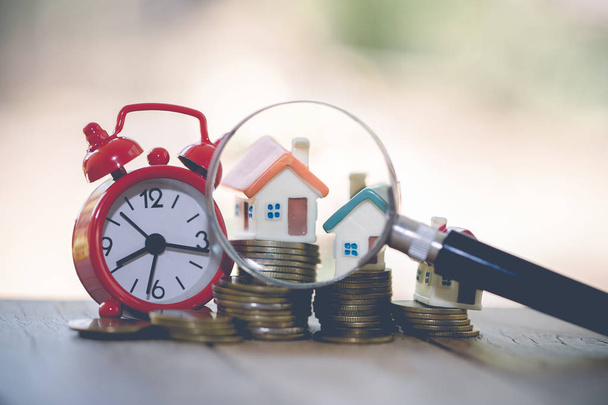 concept of a mortgage, a coin, a model of a house and a magnifying glass, house and money. magnifying glass and coins, construction, rental housing.  - Photo, Image