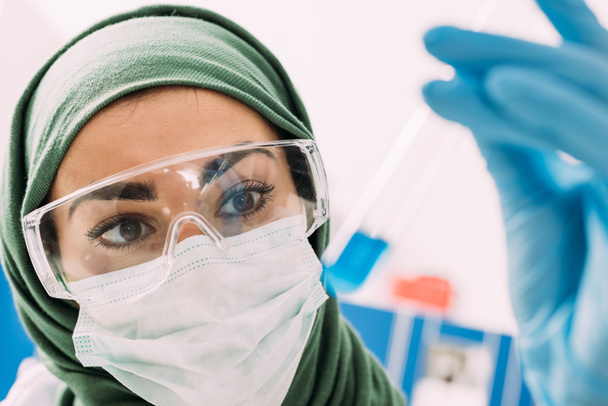 enfoque selectivo de la mujer musulmana científico celebración de tubo de ensayo en el laboratorio
 - Foto, Imagen