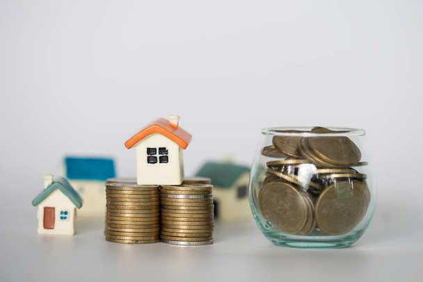Міні будинок на стопі монет, гроші та будинок, інвестиції в нерухомість, заощадження грошей зі стоп-монетами, концепція іпотеки, ізольовані
 - Фото, зображення