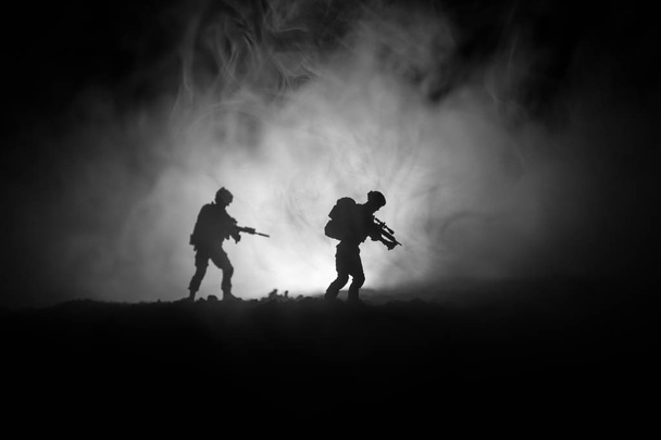 Armeijan sotilaan siluetti aseella. Sota-ajatus. Sotilaallinen siluetit taistelevat kohtaus sodan sumu taivaalla tausta, maailmansodan sotilas siluetti alla pilvinen Skyline yöllä. Hyökkäyskohtaus
 - Valokuva, kuva