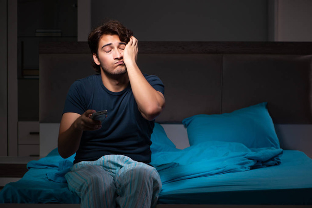 Hombre viendo la televisión por la noche en la cama
 - Foto, Imagen