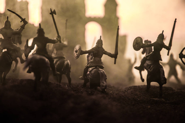 Scena di battaglia medievale con cavalleria e fanteria. Silhouette di figure come oggetti separati, lotta tra guerrieri su sfondo nebbioso tramonto. Focus selettivo
 - Foto, immagini