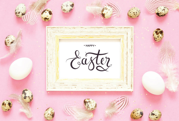 Veselé Velikonoce nápis. Velikonoční složení s velikonoční vejce a peří na růžovém pozadí. - Fotografie, Obrázek