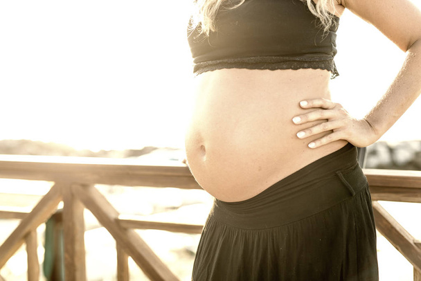 Pregnant woman on the beach, belly profile. - Photo, Image
