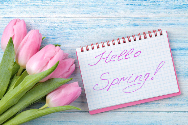 青い木製の背景に美しいピンクのチューリップの花束。春。休日。本文こんにちは春。トップ ビュー. - 写真・画像