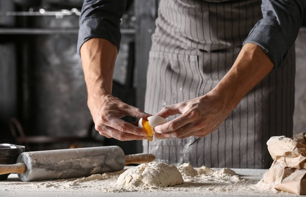 Young man preparing dough for bread in kitchen - Foto, Imagen