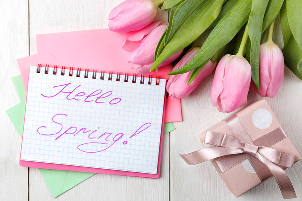 Egy csokor szép rózsaszín tulipán virágok fehér fából készült asztal. Tavaszi. ünnepek. szöveg Szia tavaszi könyv és ajándék doboz. szemközti nézet - Fotó, kép