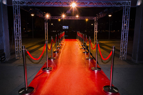 Red carpet with  barriers, velvet ropes and lights in the background - Photo, Image