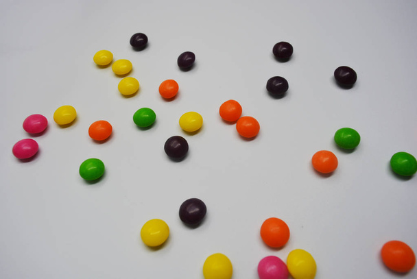 Populaire heerlijke kleurrijke zoete is op witte achtergrond. Een heleboel ronde snoepjes zijn in de vorm van lichte tabletten, dus zweterig en levendig met heldere kleuren. - Foto, afbeelding