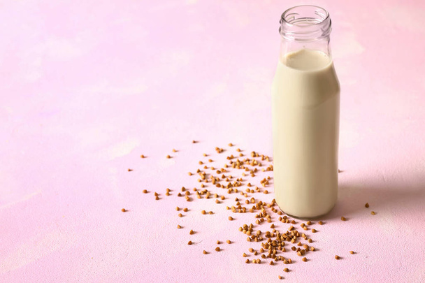 Bottle of tasty buckwheat milk on color table - Foto, Imagen
