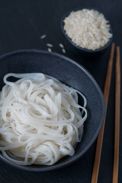 Rice noodles in a black bowl - Fotoğraf, Görsel