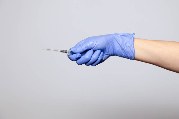 Рука крупным планом в каучуковой латексной медицине фиолетовая перчатка с трансом
 - Фото, изображение