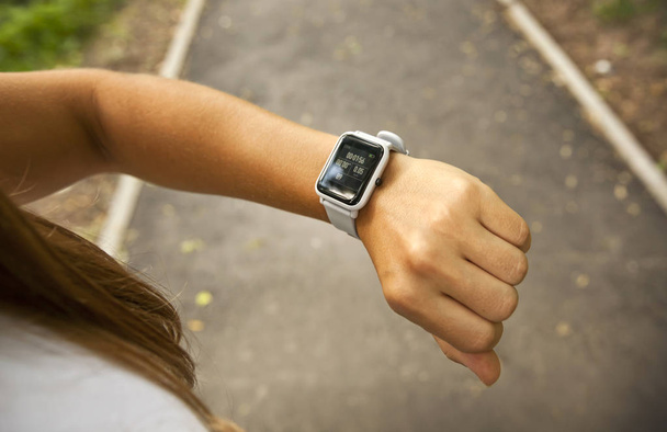 Woman is looking on her smart watches on her hand - Fotografie, Obrázek