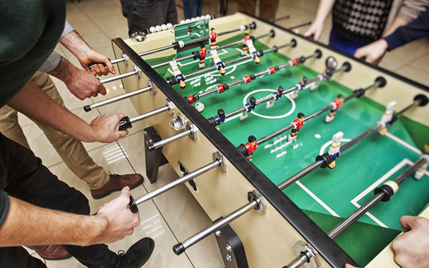 Guys are  playing table soccer indoor - Φωτογραφία, εικόνα