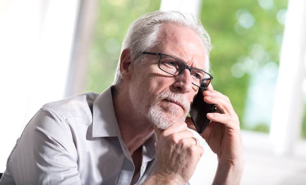 Portrait of senior businessman talking on mobile phone - Foto, Imagen