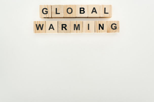 wooden cubes with "global warming" lettering on grey background - Fotó, kép