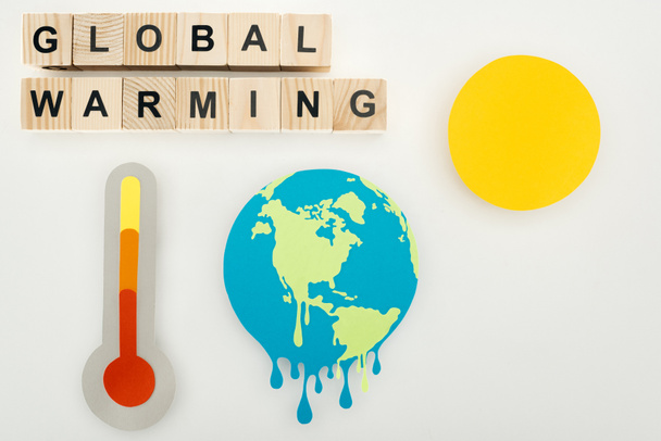 paper cut melting earth and sun, thermometer with high temperature indication on scale, and wooden cubes with "global warming" lettering on grey background - Foto, immagini