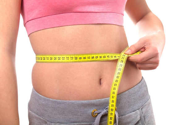 sport, fitness and diet concept, trained belly with measuring tape - Photo, Image