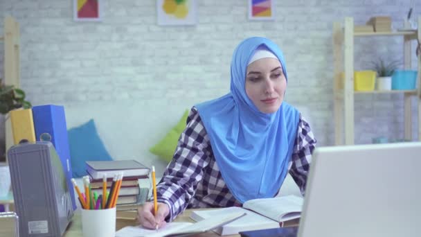 beautiful young muslim woman in hijab, studying in modern apartments portrait - 映像、動画