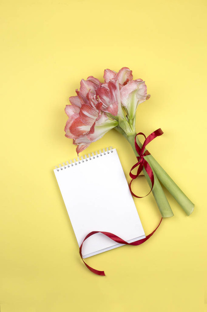 ramo vista superior de flores de primavera y cuaderno. Bloc de notas en blanco abierto y ramo de flores rosadas en la vista superior de la mesa en estilo laico plano. Top de escritorio femenino
 - Foto, Imagen