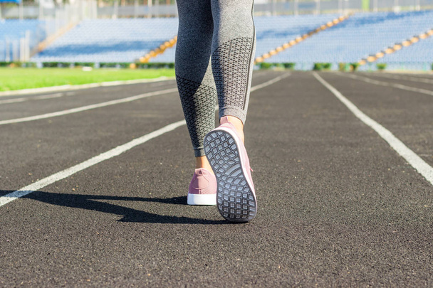 Klaar om te gaan. Close-up foto van schoen van vrouwelijke atleet op de startlijn. Meisje op stadion spoor, voorbereiding voor een run. Sport en gezond concept. - Foto, afbeelding