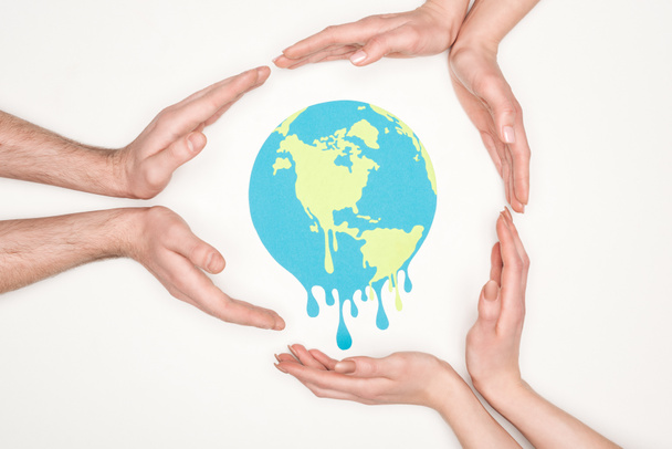 abgeschnittene Ansicht von Frauen und Männern rund um den Papierschnitt schmelzender Globus mit den Händen auf weißem Hintergrund, Konzept der globalen Erwärmung - Foto, Bild