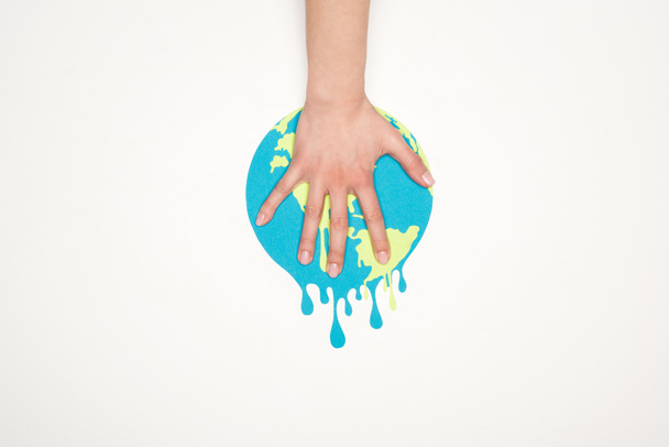 cropped view of female hand on paper cut melting globe on white background, global warming concept - Photo, Image