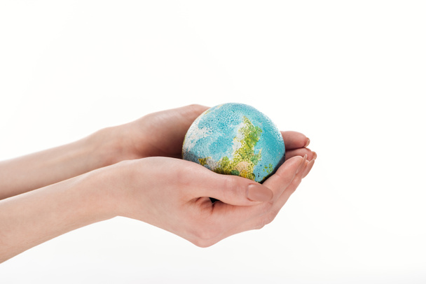 visión parcial de las manos femeninas con el modelo globo aislado en blanco, concepto de calentamiento global
 - Foto, Imagen